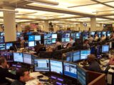 Oil traders at their desks in a Houston trading office, screens showing prices on a Monday morning