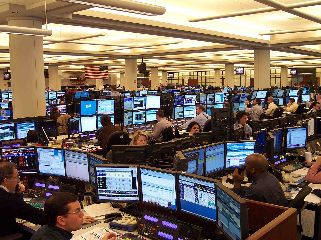 Oil traders at their desks in a Houston trading office, screens showing prices on a Monday morning