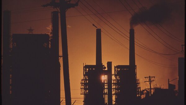 Oil refinery silhouetted at sunset